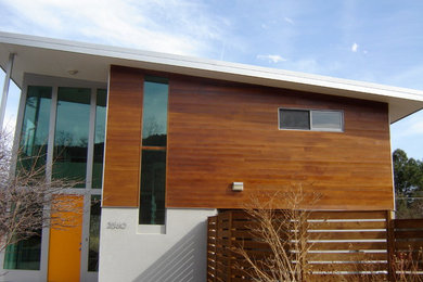 Large minimalist multicolored two-story mixed siding house exterior photo in Austin with a shed roof