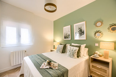 Ejemplo de dormitorio principal nórdico de tamaño medio con paredes verdes, suelo de madera clara y suelo marrón