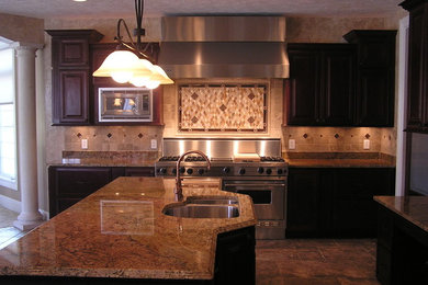 Eat-in kitchen - rustic l-shaped porcelain tile and brown floor eat-in kitchen idea in Cleveland with red cabinets, granite countertops, brown backsplash, travertine backsplash, stainless steel appliances, an island and brown countertops