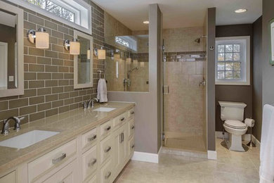 This is an example of a mid-sized traditional master bathroom in Other with an undermount sink, raised-panel cabinets, beige cabinets, an alcove shower, beige tile, subway tile, a two-piece toilet, grey walls, ceramic floors, beige floor and engineered quartz benchtops.