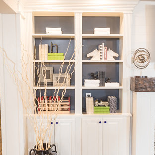 This is an example of an expansive classic walk-out basement in Cleveland with white walls, laminate floors, a two-sided fireplace, a stone fireplace surround and brown floors.