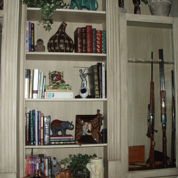 African artifacts, books, carvings and locked gun cabinet makes this library uni