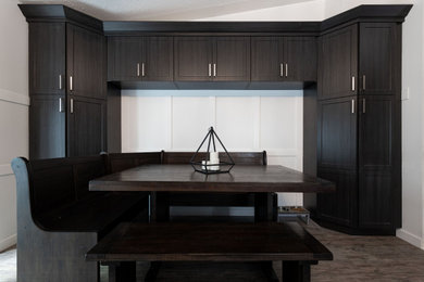 Inspiration for a small eclectic l-shaped gray floor eat-in kitchen remodel in Calgary with a double-bowl sink, shaker cabinets, black cabinets, laminate countertops, white backsplash, ceramic backsplash, stainless steel appliances, no island and black countertops