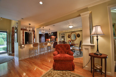 Example of a mid-sized classic light wood floor and beige floor eat-in kitchen design in Boston with a double-bowl sink, dark wood cabinets, granite countertops, paneled appliances, two islands and raised-panel cabinets