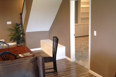 Mid-sized elegant underground laminate floor and brown floor basement photo in St Louis with brown walls