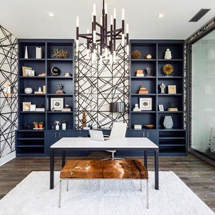 This is an example of a medium sized modern study in Los Angeles with multi-coloured walls, dark hardwood flooring, a freestanding desk and brown floors.