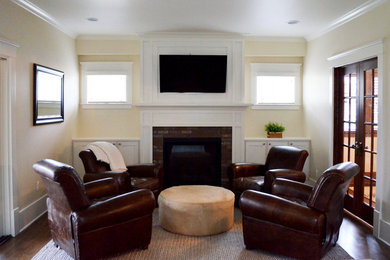 This is an example of a mid-sized traditional enclosed family room in Detroit with beige walls, dark hardwood floors, a standard fireplace, a brick fireplace surround and a wall-mounted tv.