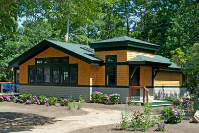 Mid-sized transitional green one-story wood exterior home photo in Boston with a clipped gable roof