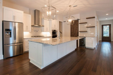 Kitchen - transitional bamboo floor and brown floor kitchen idea in Other with a farmhouse sink, shaker cabinets, white cabinets, granite countertops, gray backsplash and ceramic backsplash