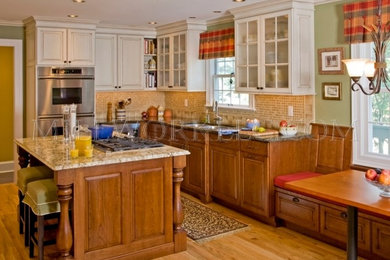 Inspiration for a mid-sized timeless u-shaped light wood floor enclosed kitchen remodel in Philadelphia with an undermount sink, raised-panel cabinets, dark wood cabinets, granite countertops, multicolored backsplash, ceramic backsplash, stainless steel appliances and an island