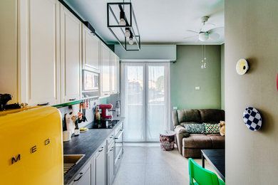 Imagen de salón ecléctico con paredes verdes, suelo de baldosas de porcelana, televisor independiente y suelo beige