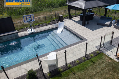 Inspiration for a mid-sized modern backyard concrete paver and rectangular pool fountain remodel in Montreal
