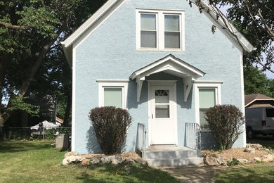 Example of a small classic blue two-story stucco exterior home design in Other with a shingle roof