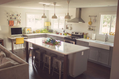 Open concept kitchen - modern u-shaped dark wood floor open concept kitchen idea in Austin with a farmhouse sink, raised-panel cabinets, gray cabinets, stainless steel appliances and an island