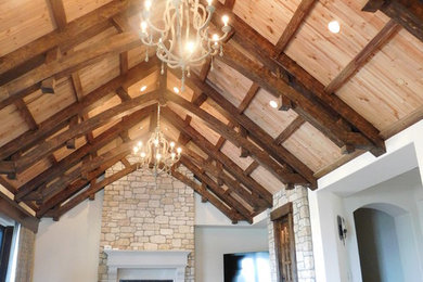 Family room - mid-sized traditional open concept medium tone wood floor and brown floor family room idea in Dallas with beige walls, a standard fireplace, a stone fireplace and no tv