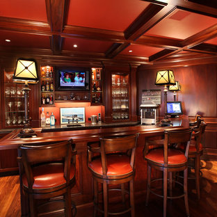 フィラデルフィアの中サイズのトラディショナルスタイルのおしゃれな着席型バー (落し込みパネル扉のキャビネット、濃色木目調キャビネット、木材カウンター、濃色無垢フローリング、茶色いキッチンカウンター) の写真