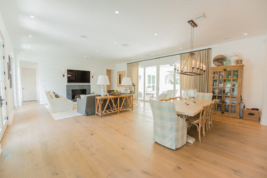 Mid-sized farmhouse medium tone wood floor and brown floor great room photo in Orlando with white walls and no fireplace