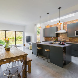 Photo of a large contemporary single-wall open plan kitchen in London with a submerged sink, flat-panel cabinets, grey cabinets, concrete worktops, stainless steel appliances, concrete flooring, an island, grey floors and grey worktops.