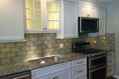 Inspiration for a medium sized traditional kitchen in Chicago with a single-bowl sink, flat-panel cabinets, white cabinets, engineered stone countertops, green splashback, metro tiled splashback, stainless steel appliances, medium hardwood flooring and brown floors.