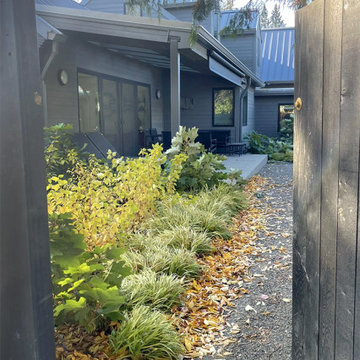 Side entry into backyard with soft plantings and covered patio shown
