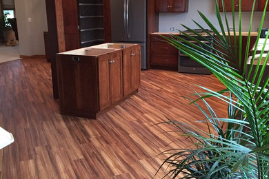 Inspiration for a transitional l-shaped vinyl floor eat-in kitchen remodel in Chicago with an island, stainless steel appliances, recessed-panel cabinets and dark wood cabinets