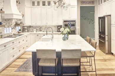 Inspiration for a large modern u-shaped medium tone wood floor and multicolored floor eat-in kitchen remodel in Miami with a farmhouse sink, shaker cabinets, white cabinets, marble countertops, multicolored backsplash, marble backsplash, stainless steel appliances, an island and white countertops