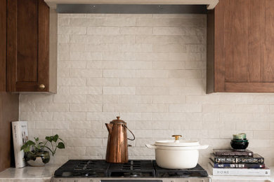 Inspiration for a huge transitional u-shaped light wood floor and beige floor enclosed kitchen remodel in Denver with flat-panel cabinets, dark wood cabinets, quartzite countertops, beige backsplash, stainless steel appliances, an island and beige countertops