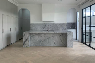 This is an example of a large traditional kitchen in Melbourne with a single-bowl sink, recessed-panel cabinets, grey cabinets, marble benchtops, light hardwood floors and with island.