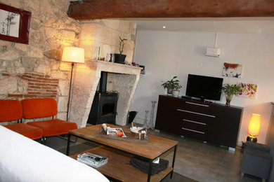 Cette photo montre un salon éclectique de taille moyenne et ouvert avec un mur beige, un sol en carrelage de céramique, un poêle à bois, un manteau de cheminée en pierre et un téléviseur indépendant.