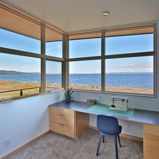 Design ideas for a medium sized modern craft room in Seattle with red walls, carpet, a built-in desk and beige floors.