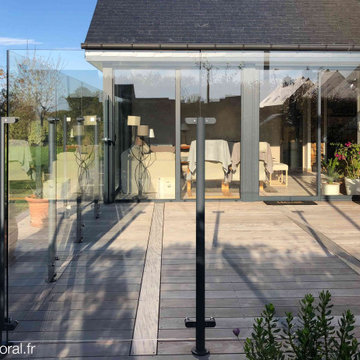 Agrandissement d'une terrasse en bois exotique avec un pare-vent en verre