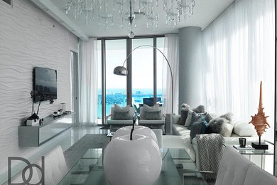 This is an example of a modern living room in Miami with white walls, marble floors and a wall-mounted tv.