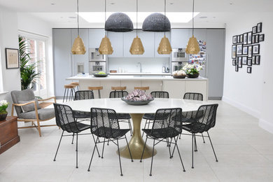Photo of a mid-sized contemporary kitchen/dining combo in London with white walls and white floor.