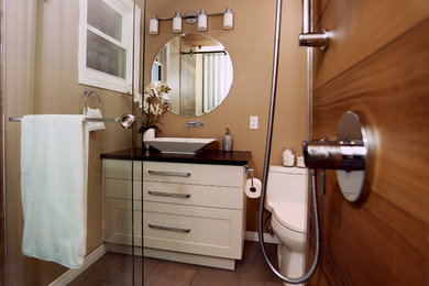 Mid-sized transitional master porcelain tile and gray floor bathroom photo in Toronto with shaker cabinets, light wood cabinets, a one-piece toilet, brown walls, a vessel sink, quartz countertops and brown countertops