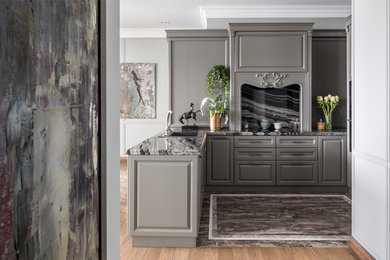This is an example of a transitional u-shaped kitchen with a drop-in sink, raised-panel cabinets, grey cabinets, grey splashback, a peninsula, grey floor, grey benchtop, marble benchtops and marble floors.
