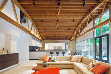 Living room - large industrial open concept concrete floor, beige floor, exposed beam and brick wall living room idea in Chicago with a bar and white walls