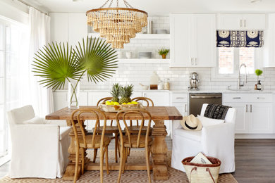 Example of a beach style dark wood floor and brown floor eat-in kitchen design in Philadelphia with an undermount sink, shaker cabinets, white cabinets, white backsplash, subway tile backsplash and stainless steel appliances