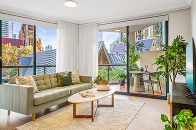 This is an example of a small modern open concept living room in Brisbane with beige walls, vinyl floors and brown floor.