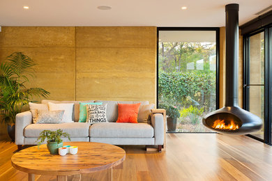 This is an example of a contemporary formal open concept living room in Melbourne with a hanging fireplace.