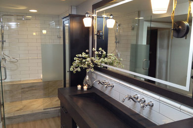 This is an example of a mid-sized contemporary bathroom in Minneapolis with a trough sink, flat-panel cabinets, dark wood cabinets, concrete benchtops, a freestanding tub, a double shower, a one-piece toilet, white tile, ceramic tile, white walls and vinyl floors.