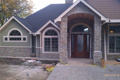 Example of a mid-sized classic one-story mixed siding exterior home design in Seattle with a shingle roof