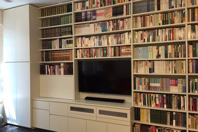 Example of a mid-sized minimalist dark wood floor living room library design in New York with white walls and a wall-mounted tv