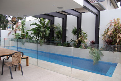 Inspiration for a modern backyard rectangular lap pool in Melbourne with natural stone pavers.