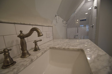 Example of a mid-sized classic master white tile and ceramic tile ceramic tile and white floor alcove shower design in Other with flat-panel cabinets, gray cabinets, a two-piece toilet, white walls, an undermount sink, marble countertops, a hinged shower door and multicolored countertops