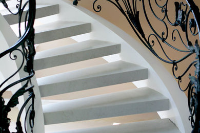 Photo of a mid-sized traditional marble spiral staircase in Moscow with metal railing.