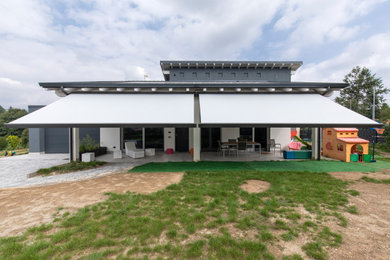 Immagine di un grande giardino minimalista esposto in pieno sole dietro casa con pavimentazioni in pietra naturale