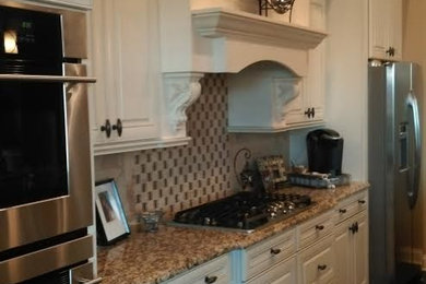 Example of a mid-sized classic galley dark wood floor and brown floor open concept kitchen design in Orlando with an undermount sink, raised-panel cabinets, white cabinets, granite countertops, beige backsplash, porcelain backsplash, stainless steel appliances and an island