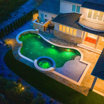 Naperville, IL freeform swimming pool with hot tub, large sunshelf, glass tile
