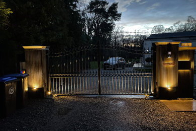 Photo of a large traditional front driveway partial sun garden for winter in Surrey with a gate, brick paving and a wood fence.