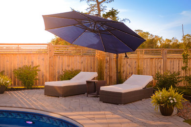 Mid-sized arts and crafts backyard concrete paver patio photo in Other with an awning